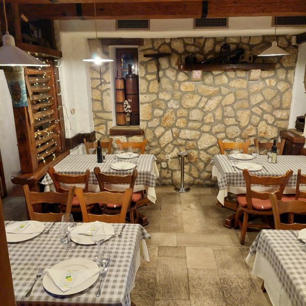Kameni zid i stolovi u Konobi Dida
